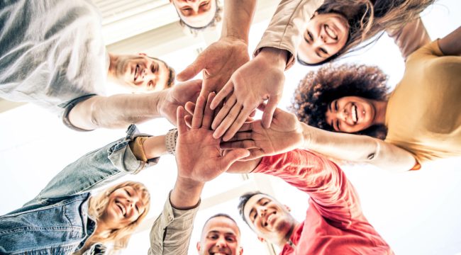 Young happy people stacking hands together outcoor - Community o